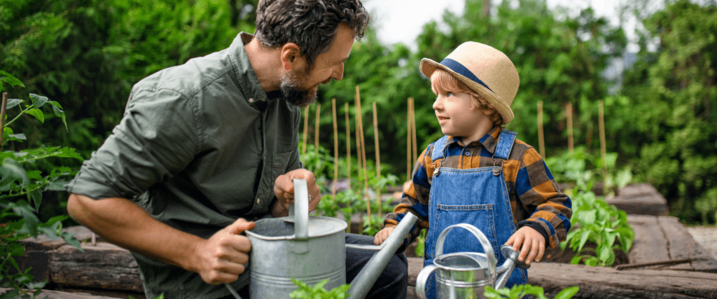 A little boy and his dad are working in the garden.